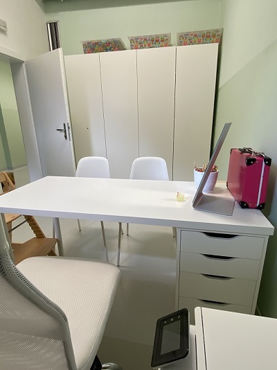 Odrinace - Bílý pracovní stůl, dvě bílé židle a bílé pracovní křeslo. V pozadí bílé skříně